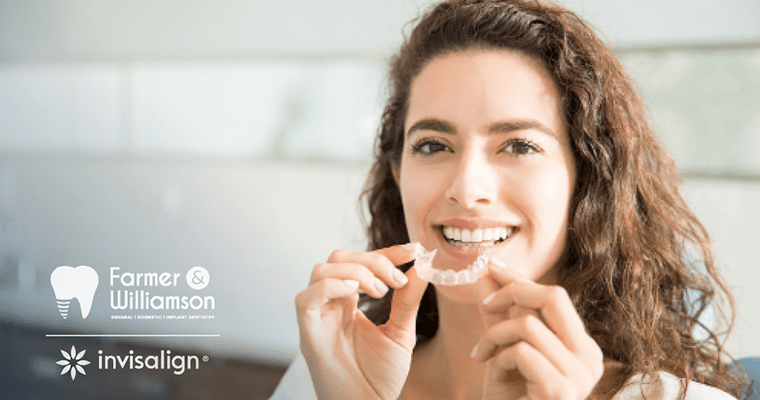 A woman holding a clear aligner addressing how does Invisalign work